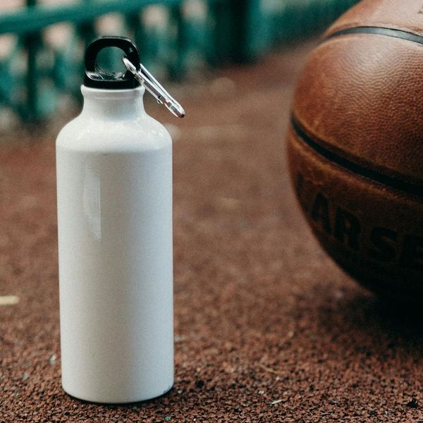 Close up of sports equipment and water bottle in dark studio.